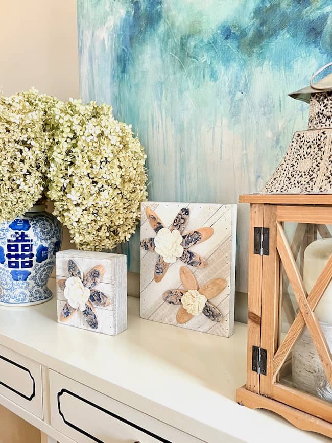 Wood Slice Spring Art Project on console table paired with dried hydrangeas and wooden lantern