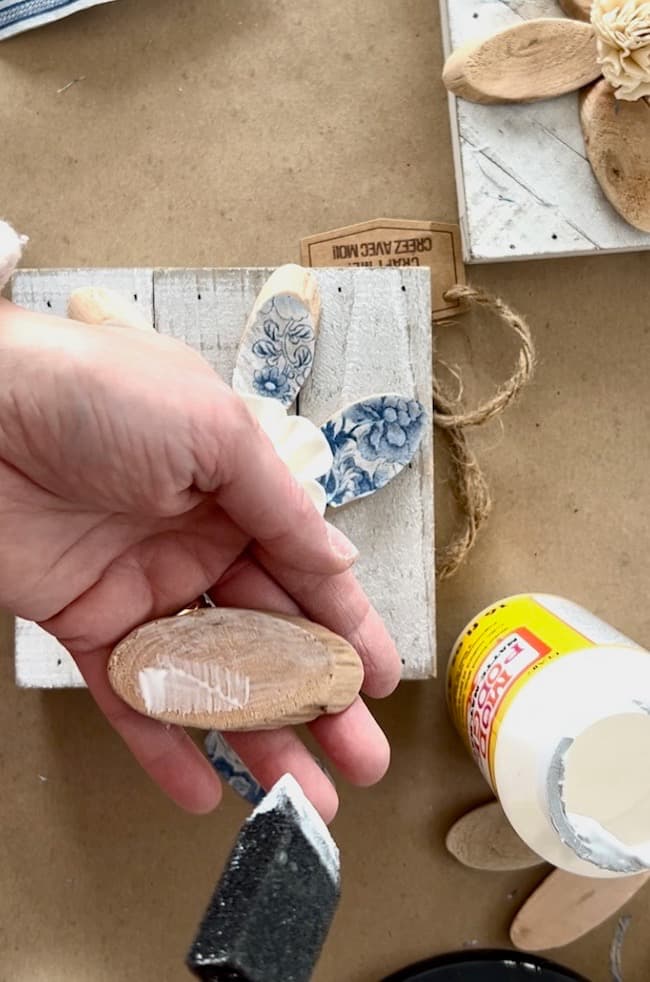 Decoupage the napkin onto the wood slice with a thin layer
