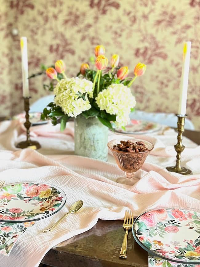 Bridal Shower Brunch Table Decor with floral plates, pink tablecloth, and tulip hydrangea centerpieces.