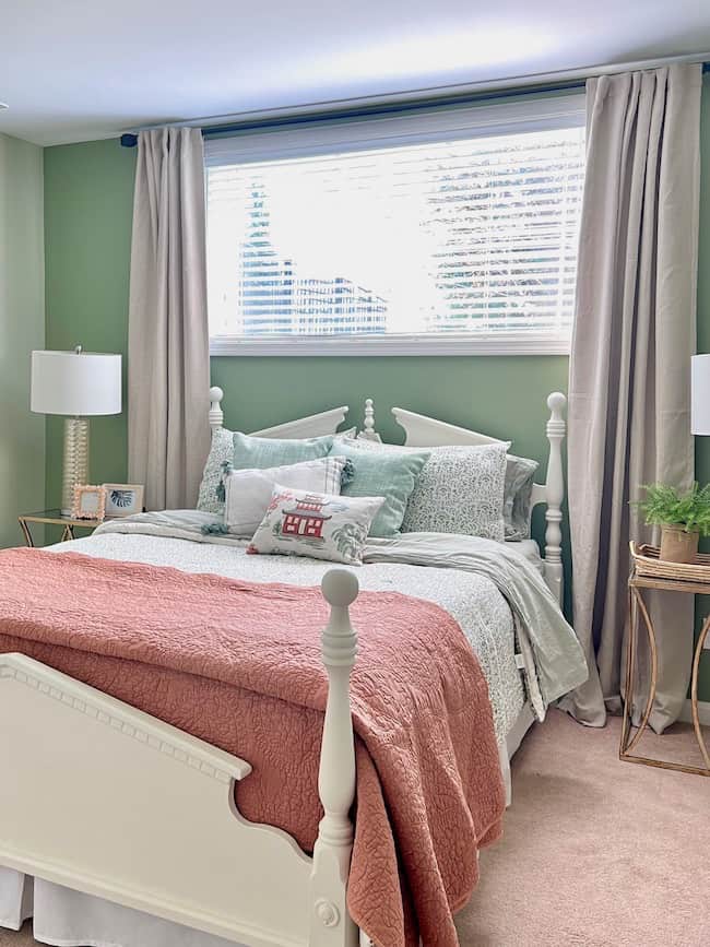 Green and coral bedroom color palette in basement bedroom