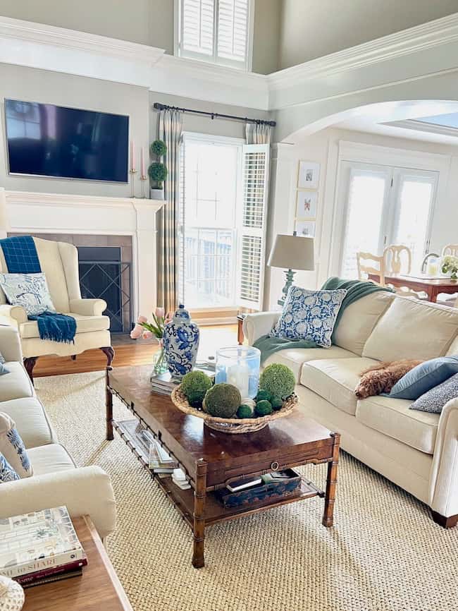 Living room with new Columbia sisal rug from Ballard Designs. Two cream facing sofas with blue patterned accent pillows.