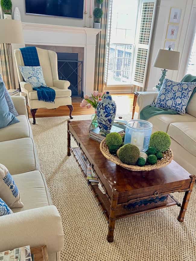 Living room with new Columbia sisal rug from Ballard Designs. Two cream facing sofas with blue patterned accent pillows.