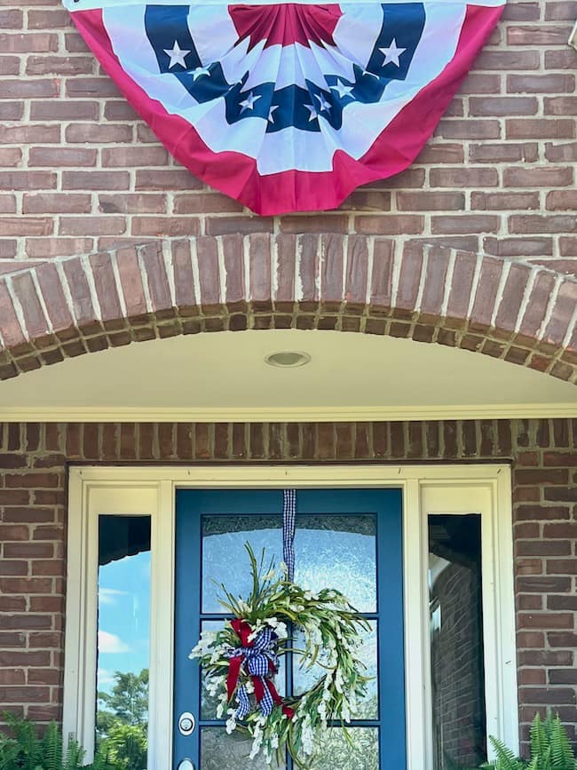 Patriotic flag bunting over front door with wreath