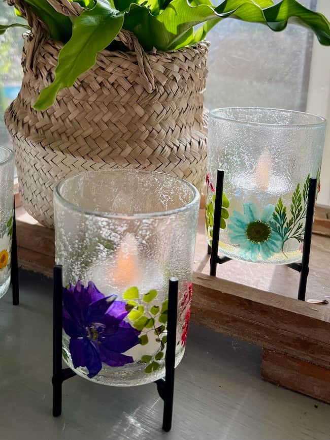 DIY Pressed flower votive holders in front of plant on the kitchen buffet