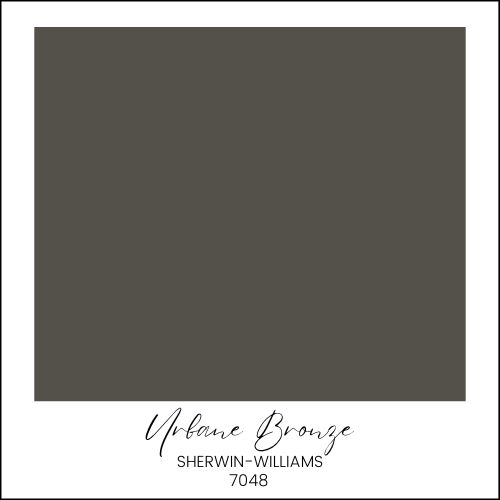 A color swatch featuring a dark grayish-brown shade with the label "Urbane Bronze" from Sherwin-Williams, number 7048, in black cursive text at the bottom. This evocative hue stands out among moody paint colors, adding depth and sophistication to any space.