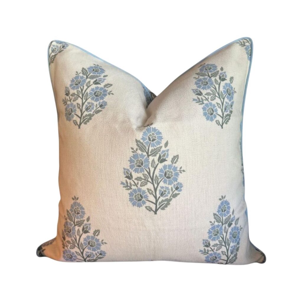 A budget-friendly square throw pillow with a beige background and a pattern of blue and gray floral designs. The pillow, available on Amazon, has a slight sheen and a crisp, tailored appearance with visible seams on the edges.