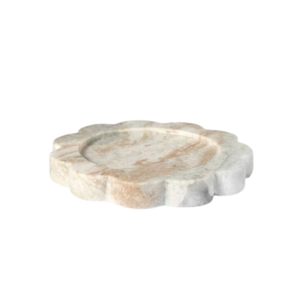 A round, flower-shaped plate made of marble with a mix of white and light brown tones. The plate has a smooth, polished surface and scalloped edges. The floral design gives it a decorative and elegant appearance.