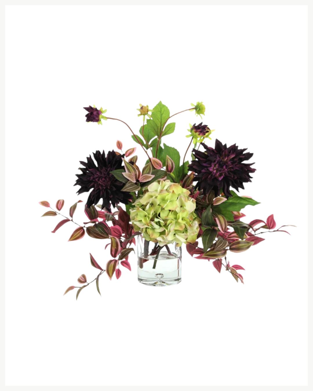 A clear glass vase holds a floral arrangement with vibrant green and purple leaves, light green hydrangeas, and dark purple dahlias. The flowers and foliage spread out dynamically, creating a visually appealing display against a white background—perfect for cozy living room decor that warms up your space.