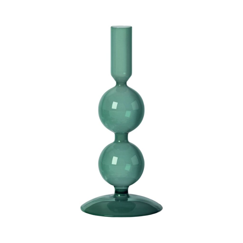 A modern, emerald green glass candle holder with a sleek design. The holder features a tall, cylindrical top section for the candle, two rounded, bulbous shapes in the middle, and a wide, stable base. The overall look is minimalist and elegant.