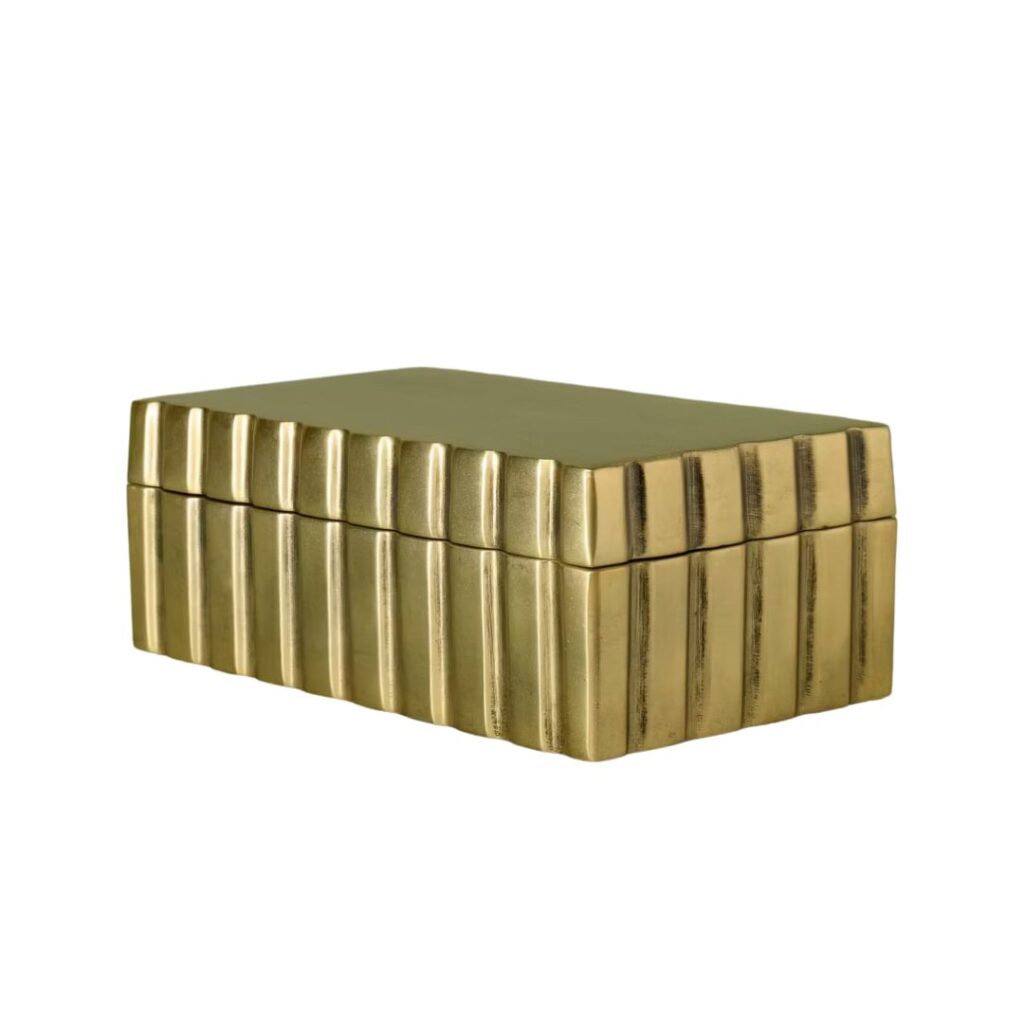 A rectangular gold jewelry box with a ridged surface. The box has a hinged lid and features a metallic finish with vertical grooves running along all sides. The overall design is sleek and modern, exuding a sense of elegance and sophistication.