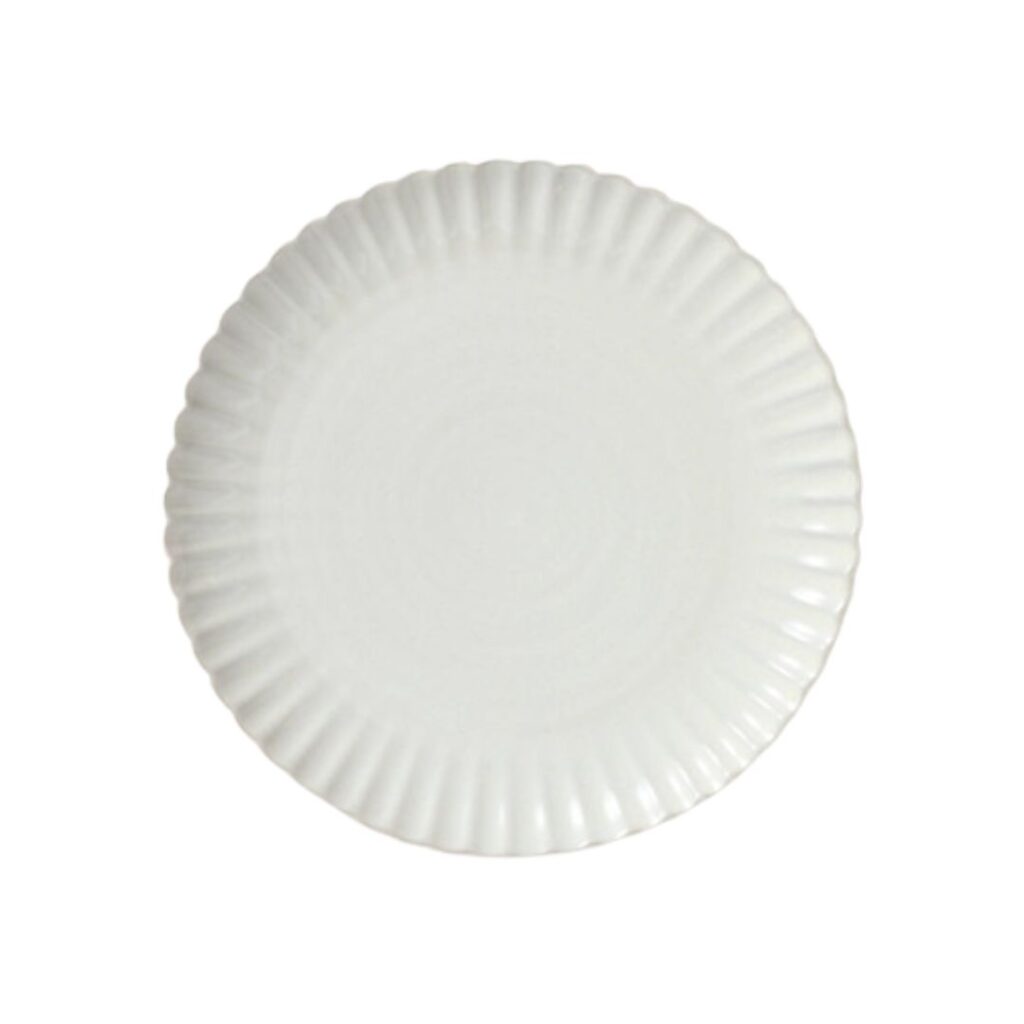 A white plate with a scalloped edge and a smooth, glossy surface. The plate is circular and simple in design, viewed from directly above against a plain white background.