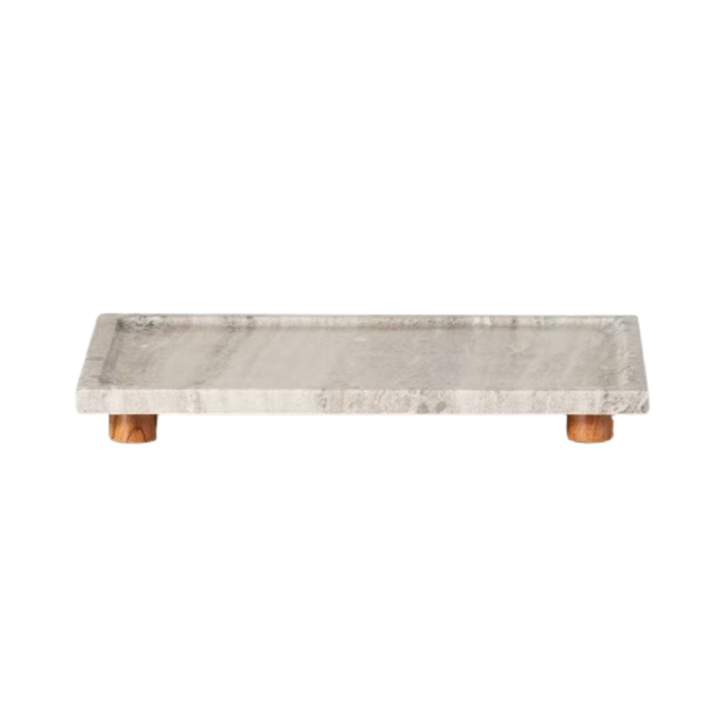 A rectangular marble tray with wooden legs, perfect for Affordable Home Decor. The tray features a smooth, polished surface and is elevated slightly off the ground by the small wooden legs. Ideal for Fall Decorating Trends 2024, this piece adds a sophisticated touch to any space.