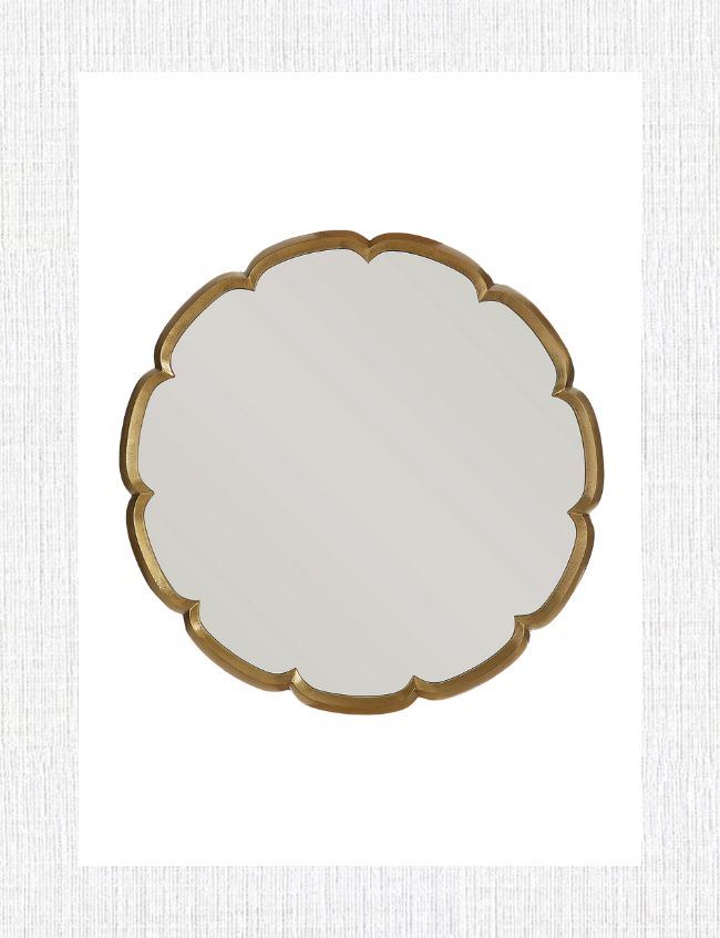 A round wall mirror with a scalloped edge and gold frame, set against a textured white background.