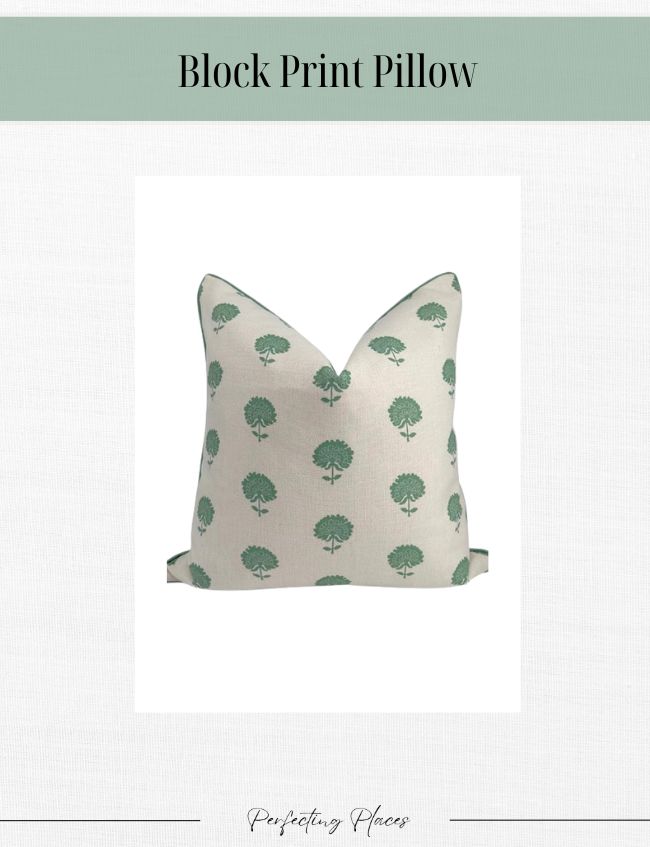 A beige pillow with a block print design of small green trees, set against a plain white background, adds a timeless look to your space. Perfect for those seeking classic home decor elegance.