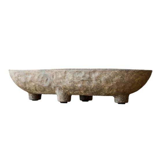 A rustic, shallow, round stone bowl with a rough texture, supported by four short, sturdy legs—perfect for those seeking ideas on how to decorate a footed bowl—shown against a plain white background.