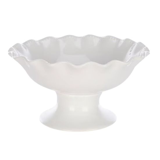 White ceramic pedestal bowl with a fluted, wavy edge. This glossy piece sits on a sturdy base—perfect for displaying fruit or florals if you're wondering how to decorate a footed bowl.