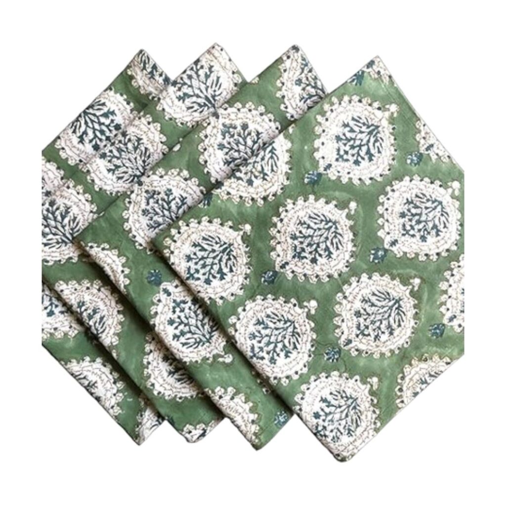 Four green cloth napkins with a white and blue floral circular pattern, neatly folded and arranged in an overlapping fan shape on a white background.