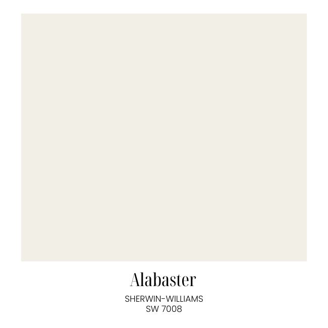 A swatch of Sherwin-Williams paint color "Alabaster" (SW 7008), displaying a soft, warm off-white shade perfect for classic cozy living room decor, with the name and code written below the color block.